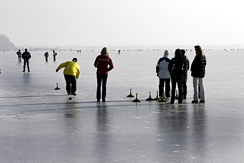 Bavarian game of Eisstock, ice stock, on frozen lake Chiemsee, Chiemgau, Upper Bavaria, Germany, Europe