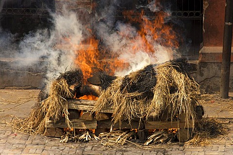 Burning pyres with visible body in a traditional funeral, Pashupatinath, Nepal, Asia