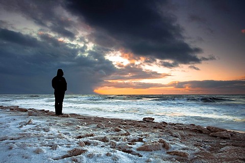 Woman looks over the North Sea at sunset on a winter's day, Sylt Island, Schleswig-Holstein, Germany, Europe