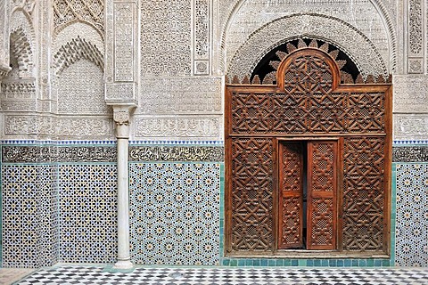 Medersa Attarine, door carved from cedar wood, walls with columns, stucco ornaments and mosaics, Fes, Morocco, Africa