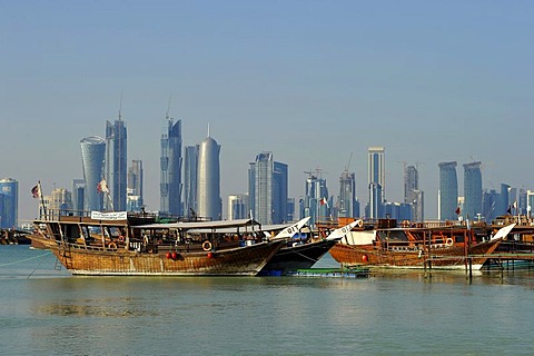 Tradition and modernity, dhow wooden cargo ships in front of the skyline of Doha, Qatar, Persian Gulf, Middle East, Asia