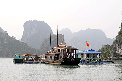 Tourist boat moored off a floating fish farm, Halong Bay, Vinh Ha Long, North Vietnam, Vietnam, Southeast Asia, Asia