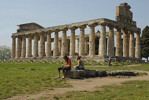 Two girls in front of Temple of Ceres in Paestum, Italy, Europe