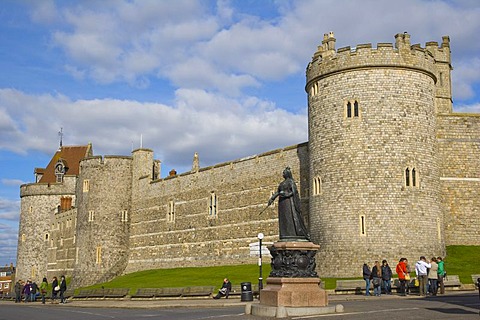 Statue of Queen Victoria against Curfew Tower and Salisbury Tower and west wall of Windsor Castle, Windsor, Berkshire, England, United Kingdom, Europe