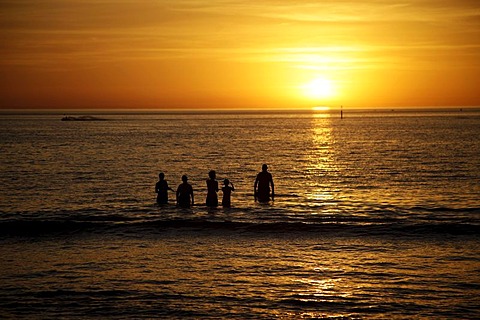 Sunset and swimmers on Glenelg beach, Adelaide, South Australia, Australia