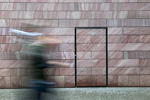 Hurried person in front of a neutral wall