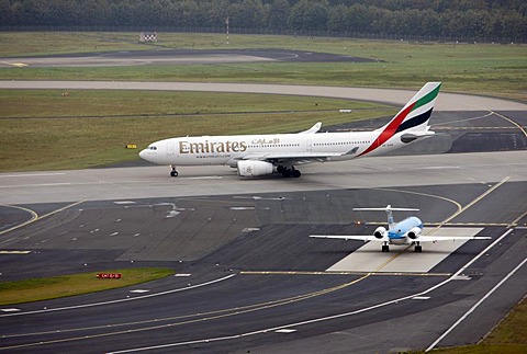 Duesseldorf International Airport, Emirates Airbus A330 on the taxiway to the runway, followed by KLM Cityhopper Fokker 70, Duesseldorf, North Rhine-Westphalia, Germany, Europe