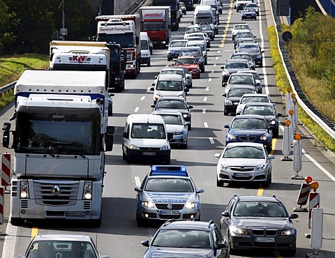 Police patrol car of the highway patrol weaving through a traffic jam to get to a car accident on the A2 highway, flashing lights and sirens, Germany, Europe