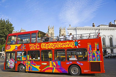 York CitySightseeing, tourist bus, against medieval York with York Minster in the back, Yorkshire, England, United Kingdom, Europe