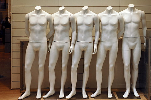 Five naked white mannequins in a fashion store