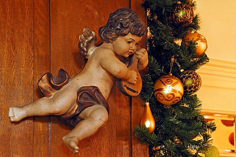 Cherub playing an instrument, carved from wood, beside pine branches with Christmas baubles, Villa & Ambiente store, Im Weller, Nuremberg, Middle Franconia, Bavaria, Germany, Europe