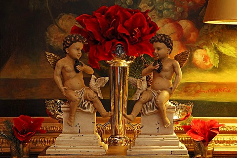 Two cherubs sitting on pillars and a silver vase with a red amaryllis in front of a painting, Villa & Ambiente store, Im Weller, Nuremberg, Middle Franconia, Bavaria, Germany, Europe