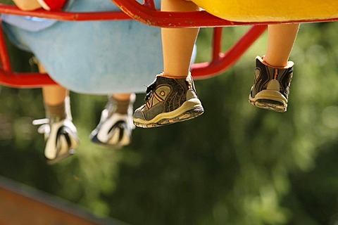 Children's legs and feet on a chair ride