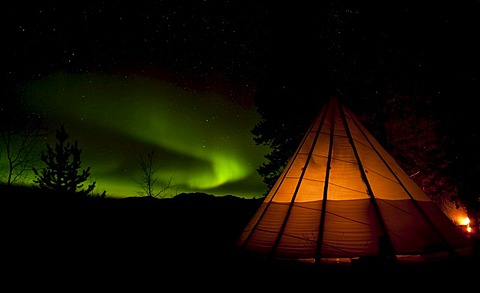 Illuminated teepee, tipi, tepee, Northern Lights, Polar Lights, Aurora Borealis, green, swirling, near Whitehorse, Yukon Territory, Canada