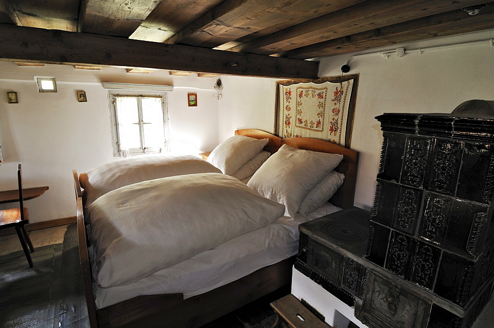 Bedroom with tiled stove, Glentleiten farming museum, Bavaria, Germany, Europe