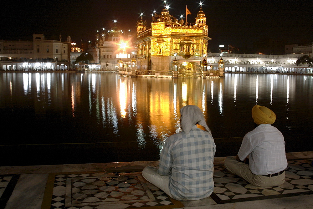 Two men with view of the Golden Temple, Amritsar, Punjab, India, South Asia