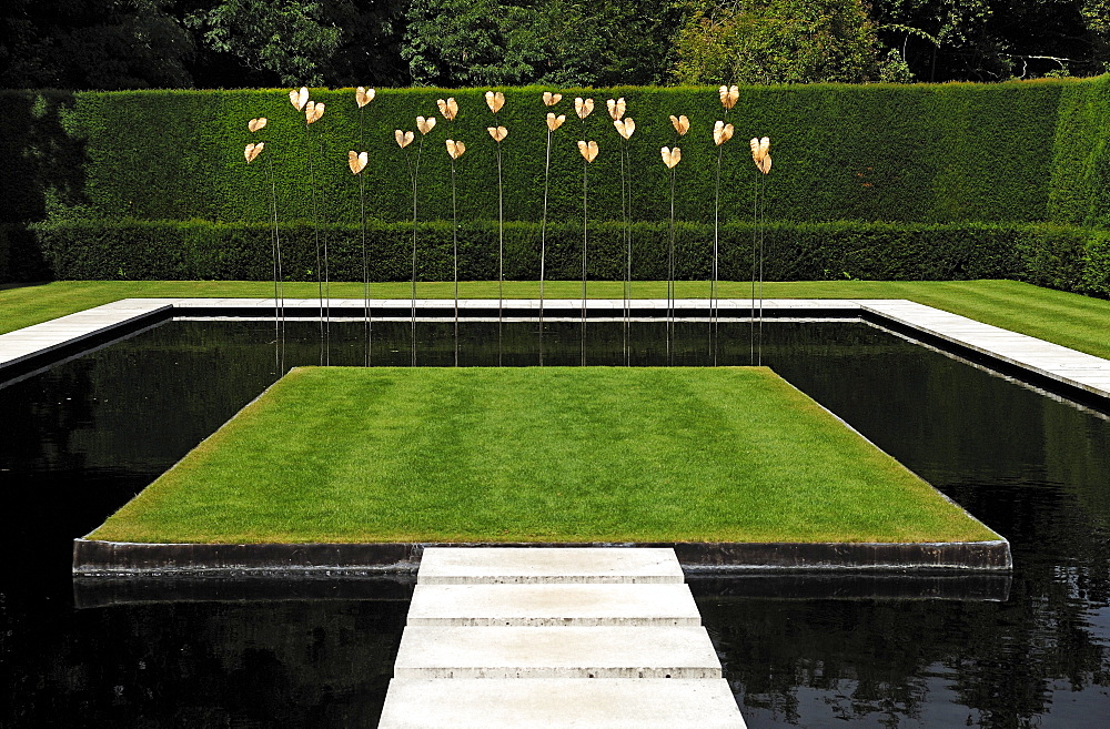 Modern art by Simon Allison, gold-plated bronze leaves on steel rods in a modern pond in Kiftsgate Court Gardens, Mickleton, Chipping Campden, Gloucestershire, England, United Kingdom, Europe