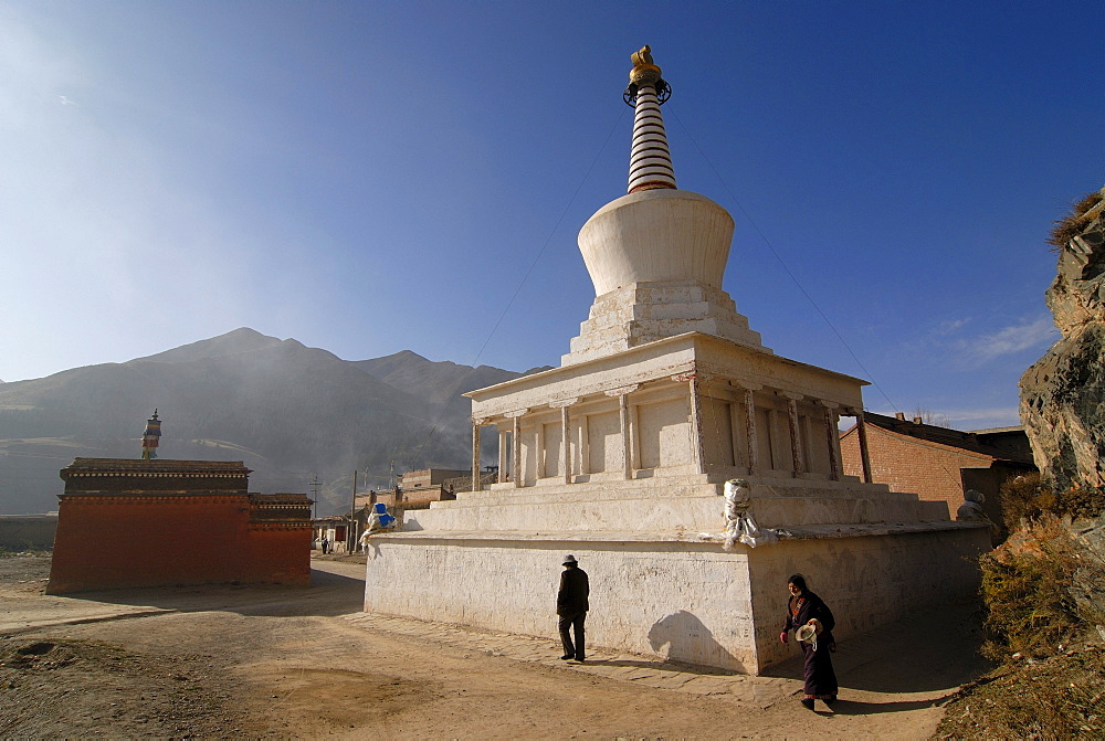 Two women circling a stupa of the Labrang monastery, Xiahe, Gansu, China, Asia