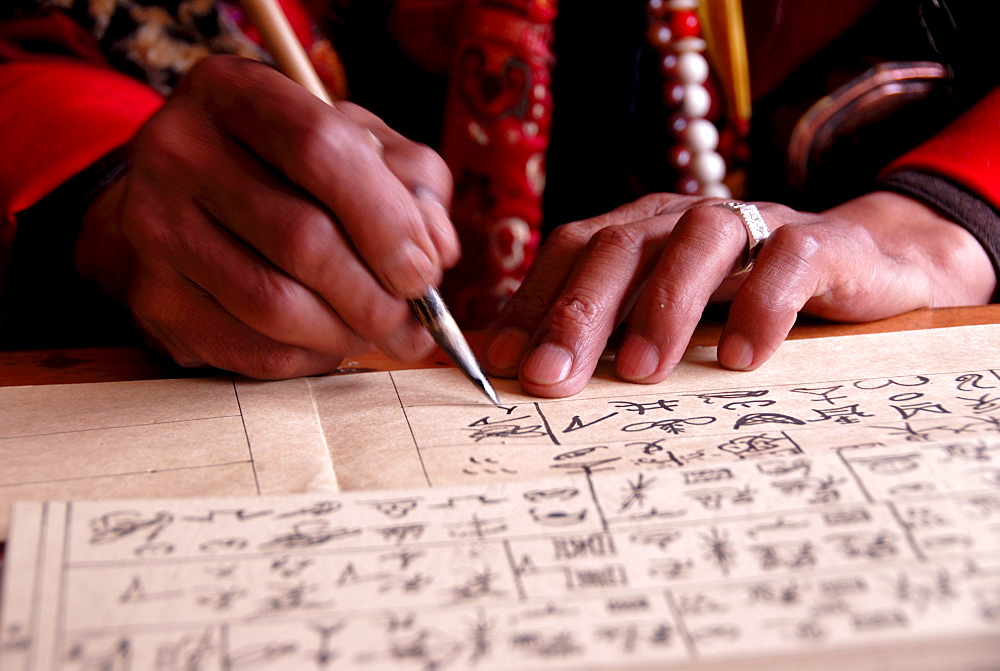 Priest writing ancient Dongba script, hands, Dongba Research Center at the Black Dragon Pool, Lijiang, UNESCO World Heritage Site, Yunnan Province, People's Republic of China, Asia