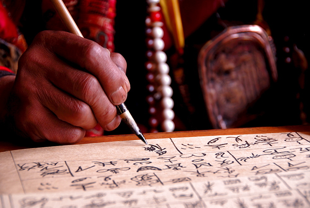 Priest writing ancient Dongba script, hands, Dongba Research Center at the Black Dragon Pool, Lijiang, UNESCO World Heritage Site, Yunnan Province, People's Republic of China, Asia