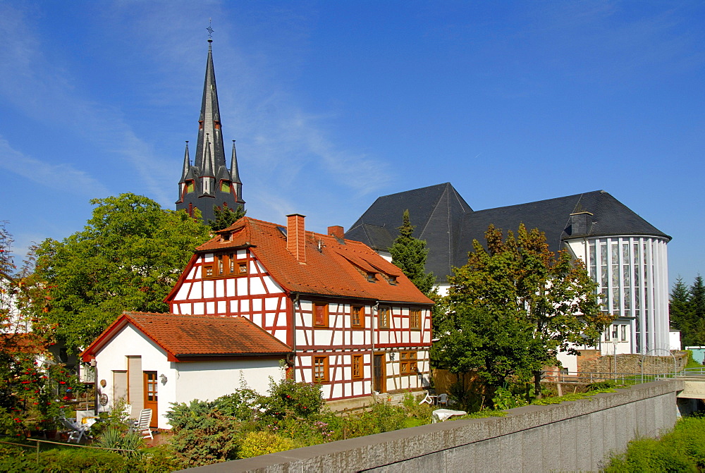 Half-timbered house in front of the Catholic parish church of St. Markus, Muehlheim am Main, Hesse, Germany, Europe