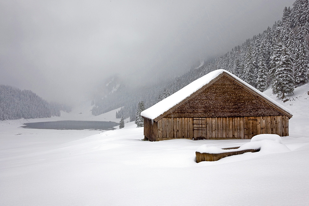 Alpine hut in winter mood, in the back back the Saemtisersee see in the Alpstein range, Switzerland, Switzerland, Europe