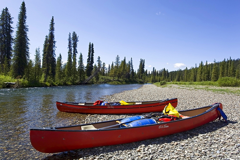 Two loaded canoes on the shore of upper Liard River, gravel bar, Yukon Territory, Canada