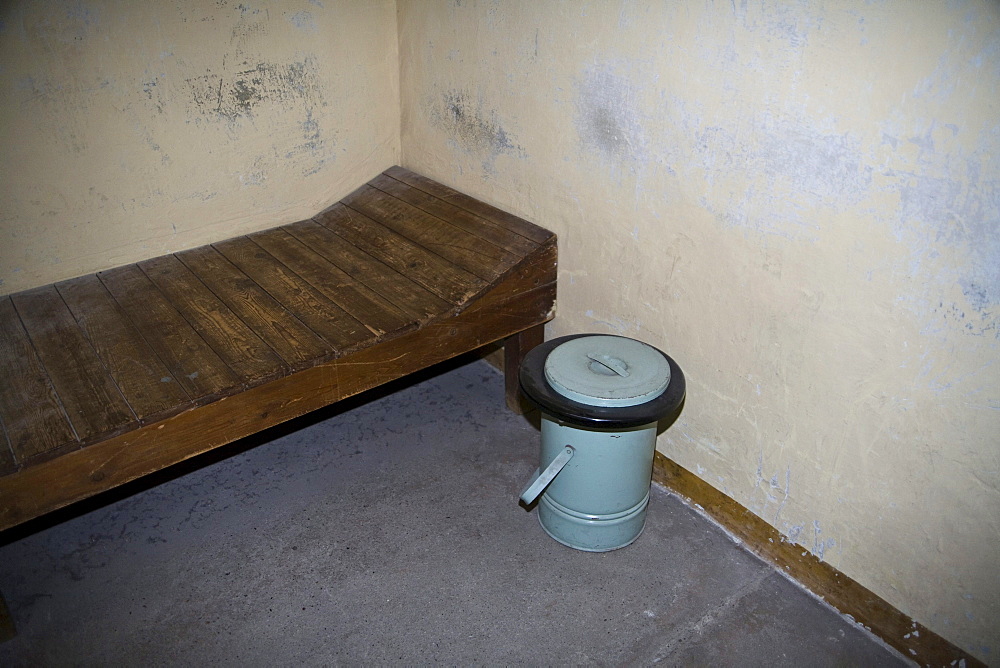 Cot with toilet bucket in a windowless cell for solitary confinement, Berlin-Hohenschoenhausen memorial, former prison of the GDR's secret service, Berlin, Germany, Europe