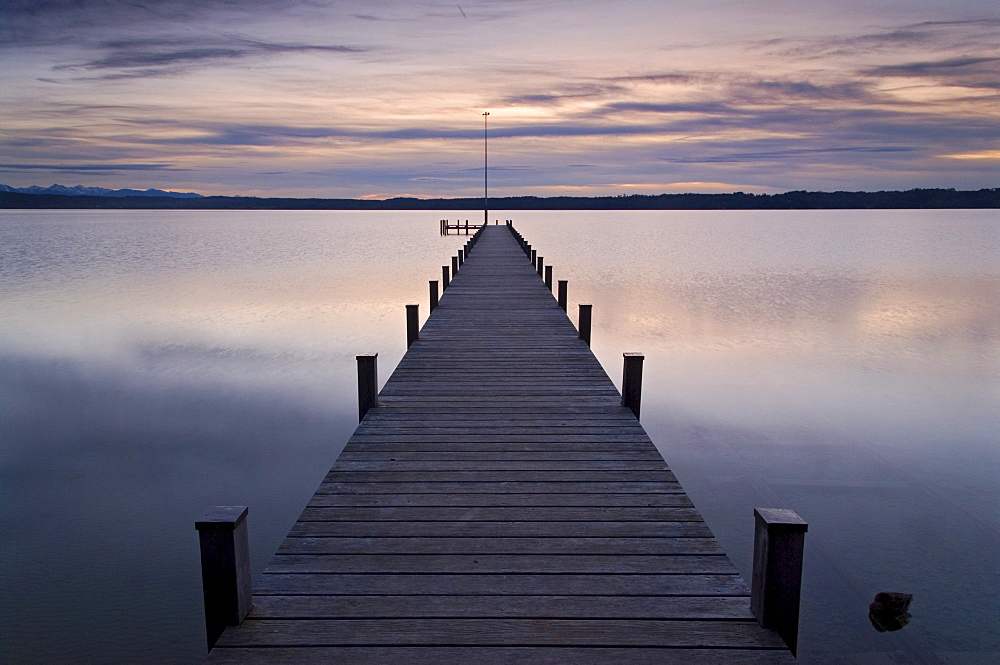 Pier into Lake Starnberg in front of a colorful sunset, near Ambach, Bavaria, Germany, Europe