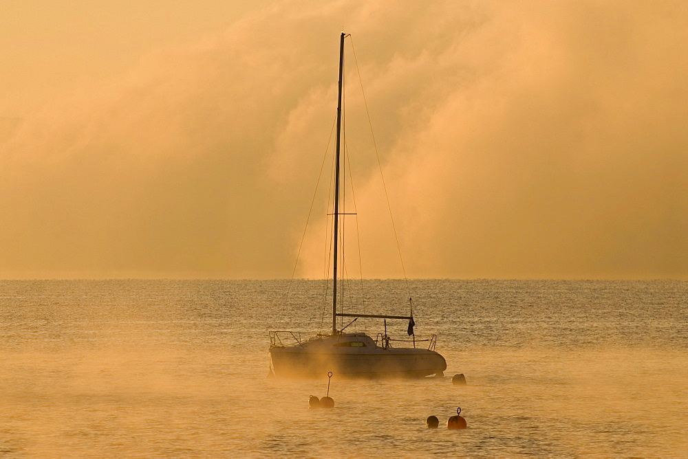 Sailing boat and low morning fog over Ammersee lake at Utting, Bavaria, Germany, Europe