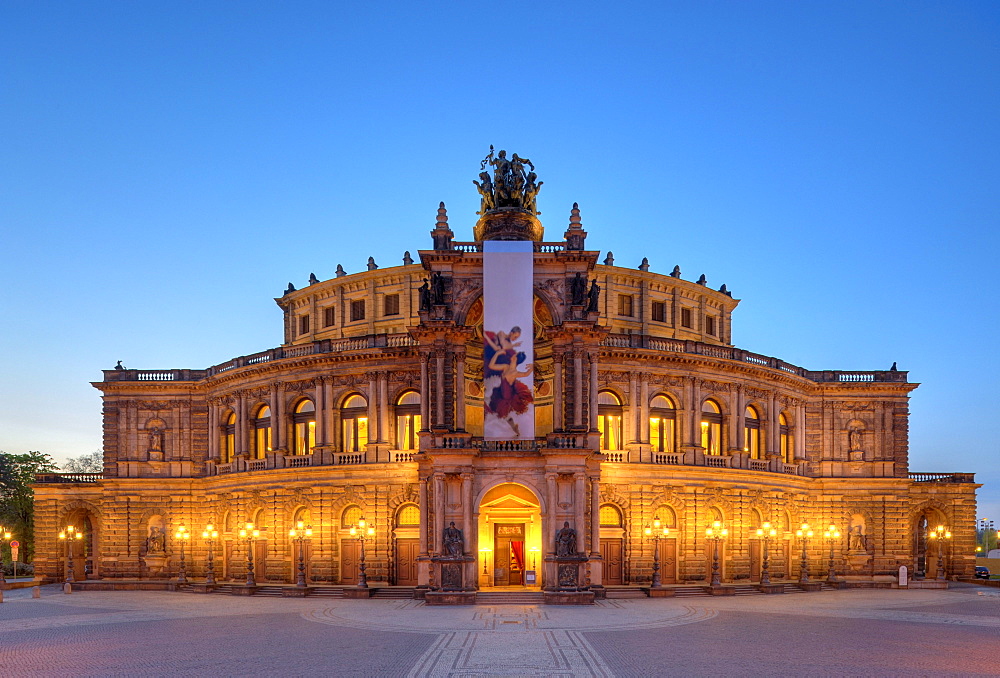 Night shot, illuminated Semperoper opera house with flags, Theaterplatz square, Dresden, Free State of Saxony, Germany, Europe