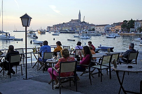 Cafe at sunset overlooking the Old Town and harbor, Rovinj, Istria, Croatia