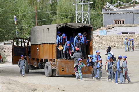 Schoolchildren in school uniform getting out of a truck that serves as a school bus, Secondary Senior School, Lamdon, Leh, Jammu and Kashmir, India, Himalayas, Asia