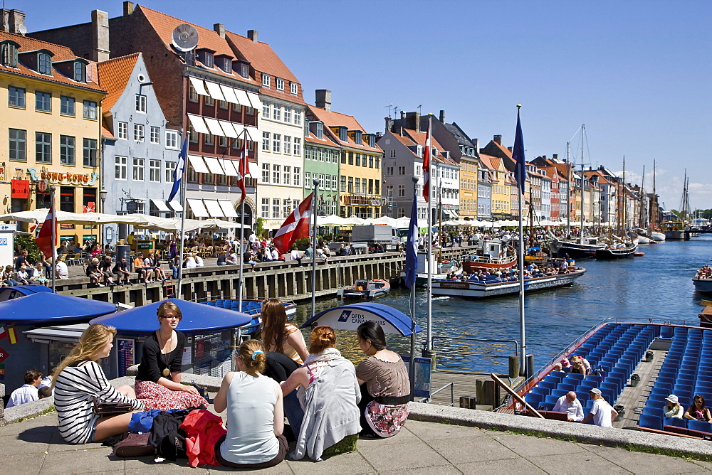 Tourists relaxing in Nyhavn, Copenhagen, Denmark