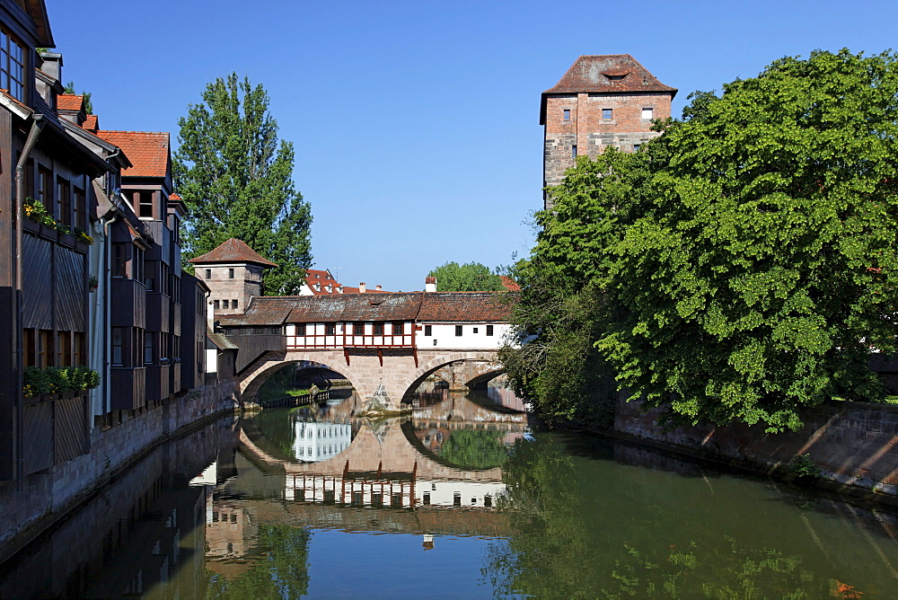 Executioner's home with half-timbered building, bridge building with two arches, small fortified tower and high water tower, Pegnitz river, trees, reflection, old town, Nuremberg, Middle Franconia, Franconia, Bavaria, Germany, Europe