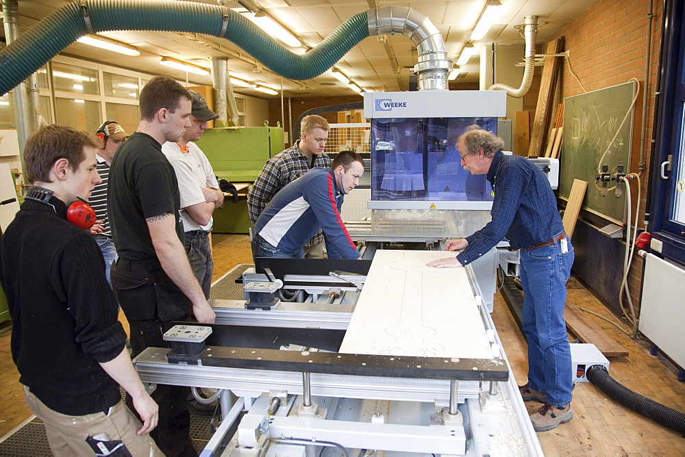 Specialist lecturer demonstrating a computer numerical control (CNC) milling machine, Master Craftman School of the Chamber of Small Industries and Skilled Trades for carpentry, Dusseldorf, North Rhine-Westphalia, Germany, Europe