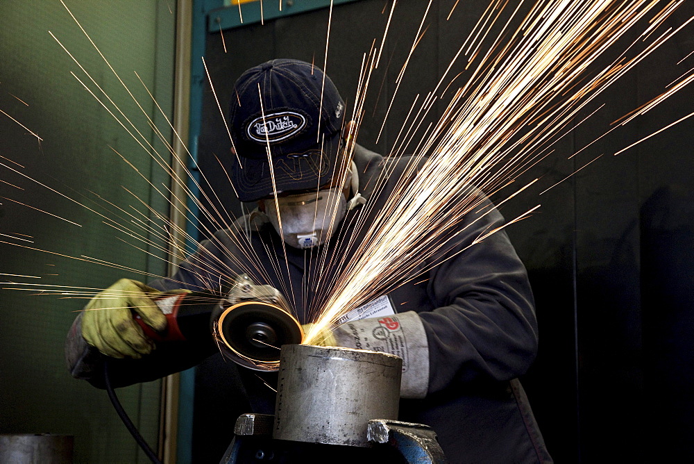 Apprentice grinding with an angle grinder in the welding workshop during a welding course of the School of the Chamber of Small Industries and Skilled Trades, Duesseldorf, North Rhine-Westphalia, Germany, Europe