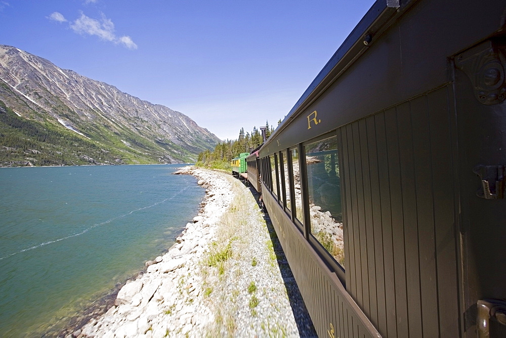 Historic White Pass & Yukon Route Train going alongside Lake Bennett toward Carcross, Klondike Gold Rush, Chilkoot Pass, Chilkoot Trail, Yukon Territory, British Columbia, B. C., Canada