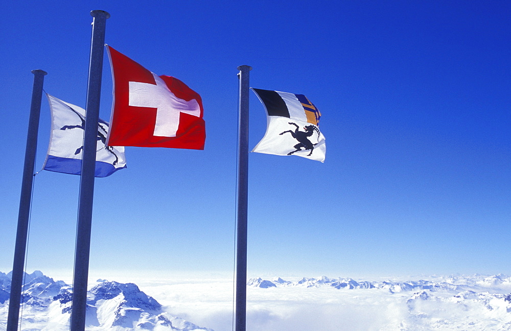 Flags of Graubuenden and Switzerland on the summit of Mount Corvatsch near Silvaplana, Engadin, Graubuenden or Grisons, Switzerland, Europe