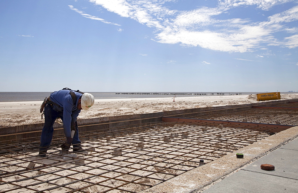 Workers construct a concrete boardwalk along the Gulf of Mexico to replace the boardwalk that was washed away by Hurricane Katrina, Biloxi, Mississippi, USA, Biloxi, Mississippi, USA