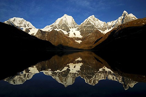 Laguna Carhuacocha at sunrise, from left, Siula Grande, Yerupacha, Yerupacha Chico, and Jirishanca behind, Cordillera Huayhuash, Peru, South America