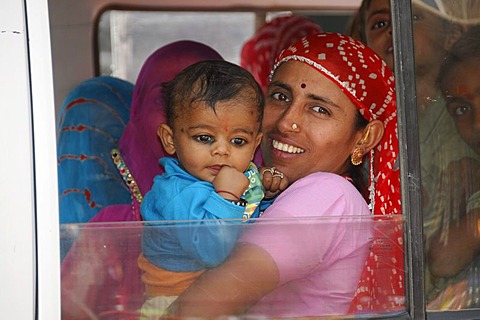 Indian woman holding a child in a fully occupied car, near Jodhpur, Rajasthan, North India, Asia