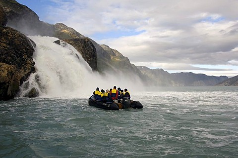 Zodiac with tourists approaching a waterfall, Arsuk Fjord, Greenland, Denmark