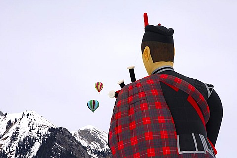 Hot-air balloons, rear view of the special form of a flying scotsman, Cameron ss Balloon Piper-105, two round balloons over snow-covered mountains, Balloon festival Chateau d'Oex, Switzerland, Europe