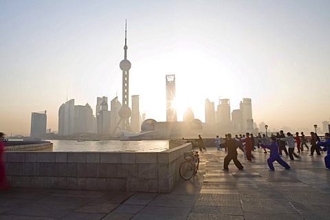 Chinese people practicing Tai Chi at the Bund, in front of the Pudong Skyline, Shanghai, China, Asia