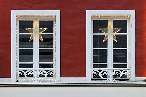 Christmas decoration, stars and chain of lights on crown glass windows