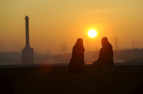 Two people in the forefront of EnBW Energiepark at sunset, Marbach on the Neckar, Baden-Wuerttemberg, Germany, Europe