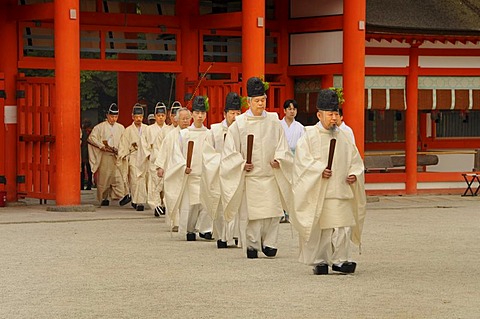 Shinto priests at archery opening ceremonial in Shimogamo Shrine, striding through entrance gate, Kyoto, Japan, Asia