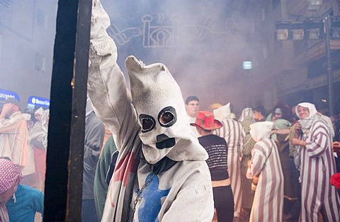 During the Correfoc or Fire Run, hooded Fire Devils run through the streets of Spanish towns brandishing fireworks, Altea, Costa Blanca, Spain, Europe