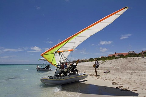 Pilot of a motorised hang glider waiting for passengers on a beach, UL-Trike, Ultra Light airplane with a life boat, Varadero, Cuba, Caribbean, Central America, America